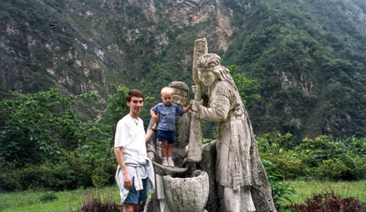 Standing next to some statue in the mountains